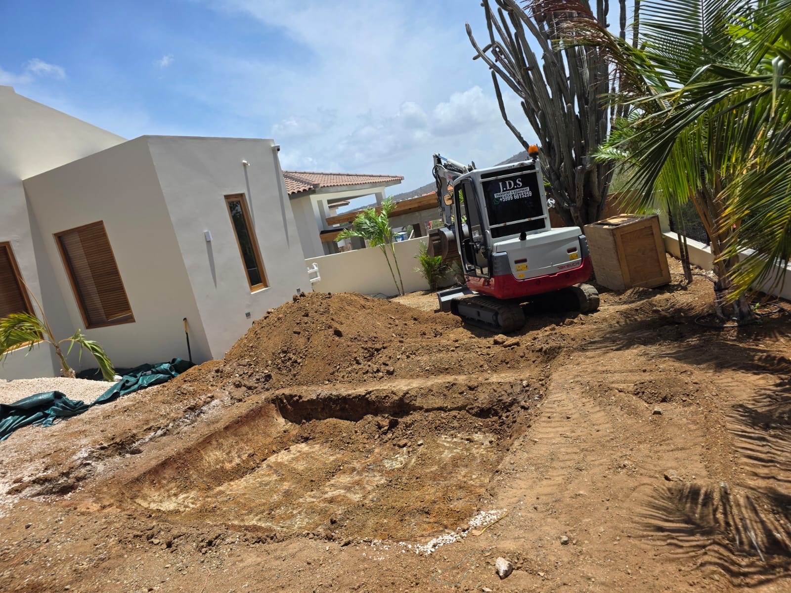 JDS excavator carrying out residential groundwork near a house