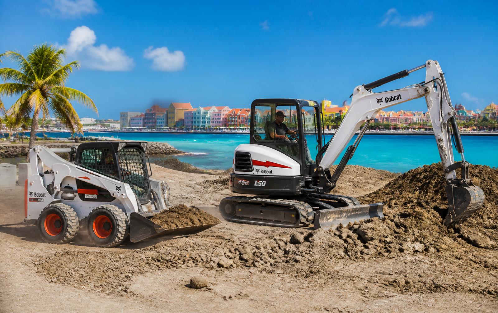 Bobcat and excavator working on a site in Curaçao with the colourful Handelskade in the background